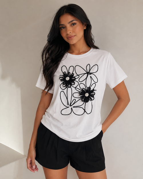 Blusa blanca con flores en relieve y detalle negro bordado