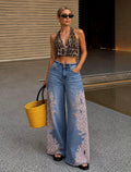 Woman wearing leopard print wide-leg jeans with leopard halter crop top and wicker bag