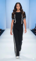 Model wearing black and white stripe trim two-piece set on runway